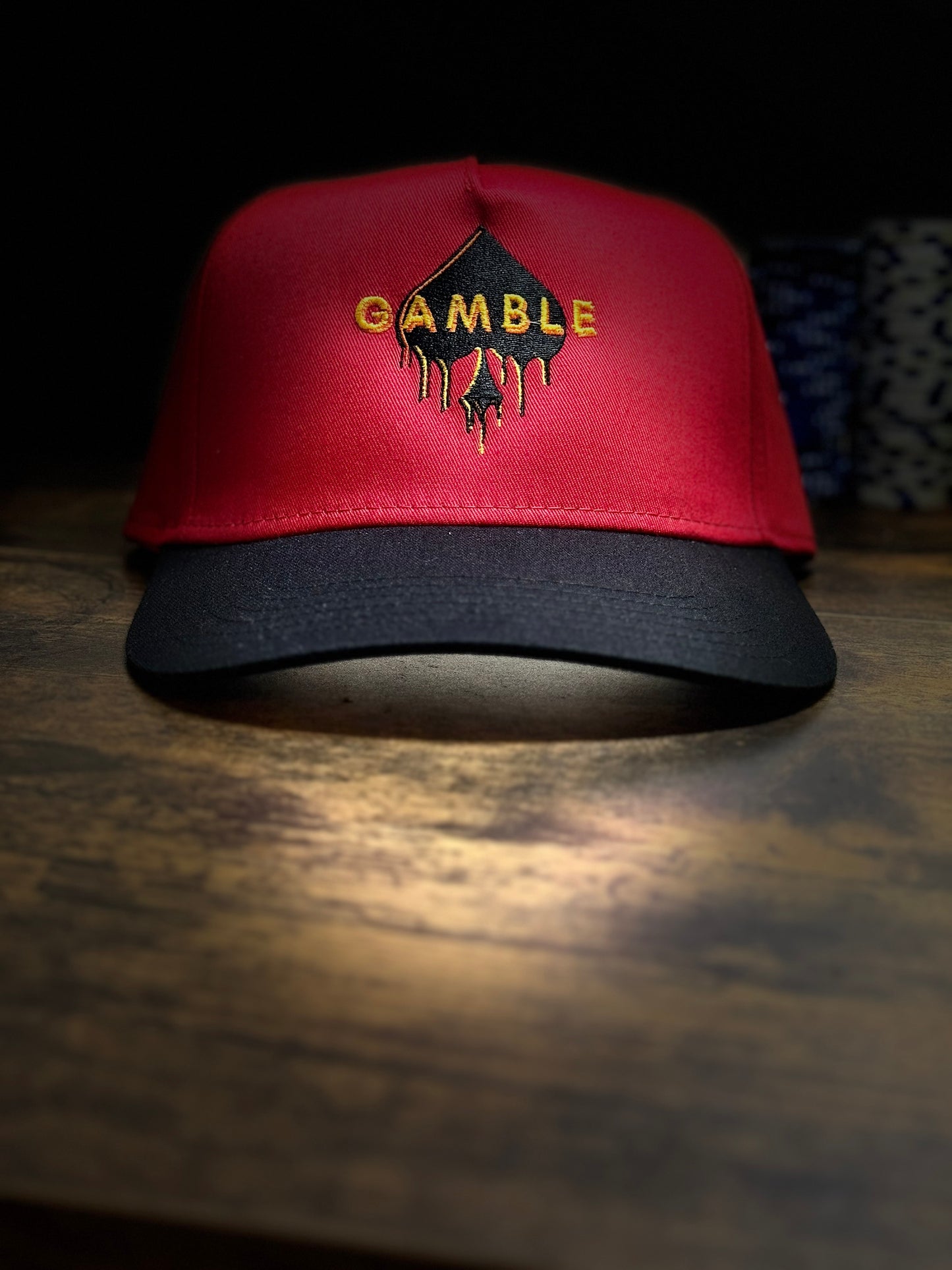 Red poker snapback hat with an embroidered ‘Gamble Drip’ design in bold lettering. Structured fit with an adjustable snapback closure. Perfect for poker players who embrace high stakes and bold moves.