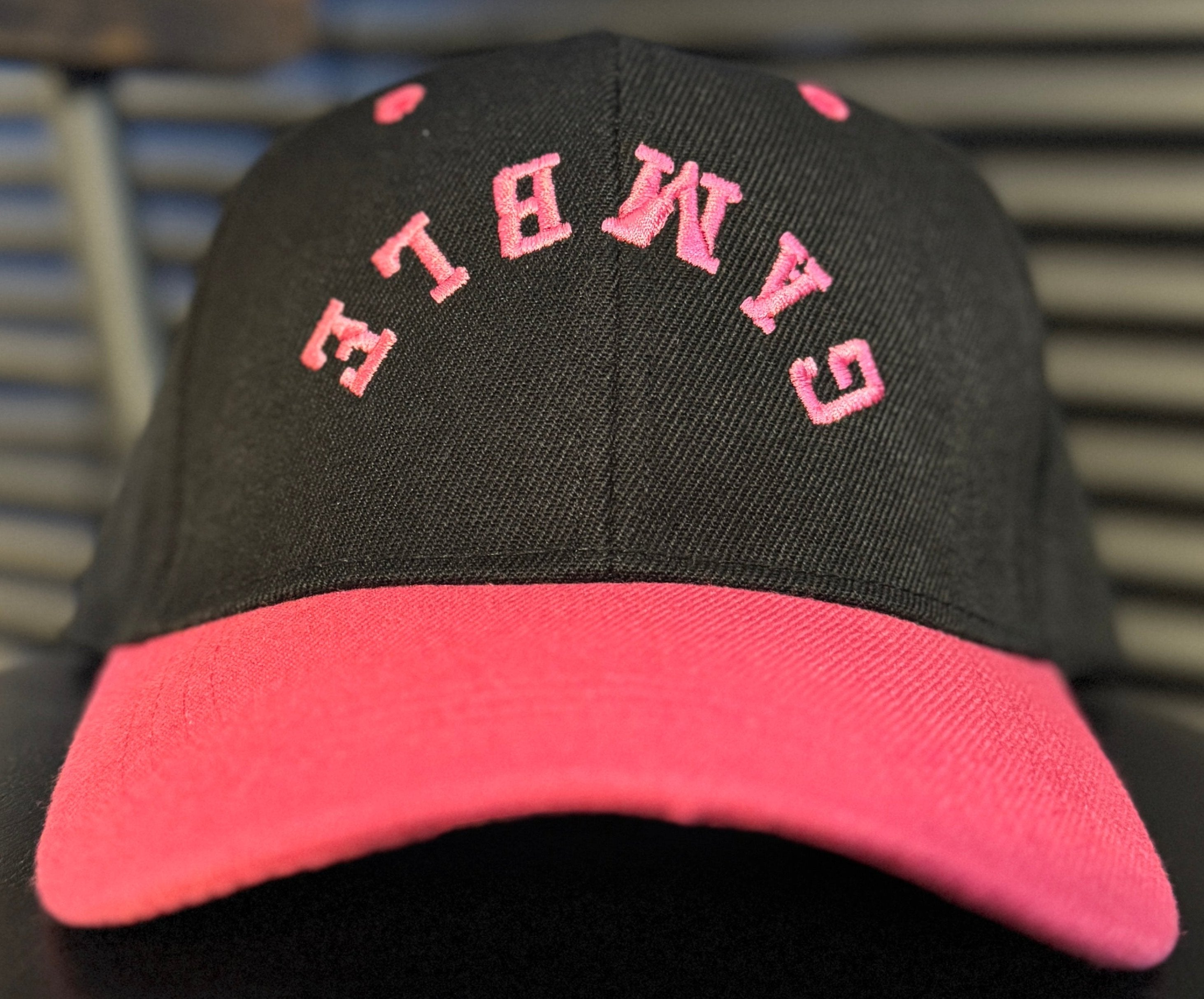 pink poker hat with bold embroidered logo, featuring a sleek design perfect for any poker enthusiast. Ideal poker clothing for players looking to make a statement both on and off the tables.