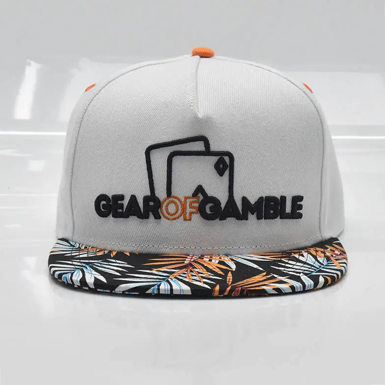 white snapback hat with a bold leaf-patterned brim and Gear of Gamble logo on the front. Perfect poker apparel for players who want to showcase their love for the game with a unique twist