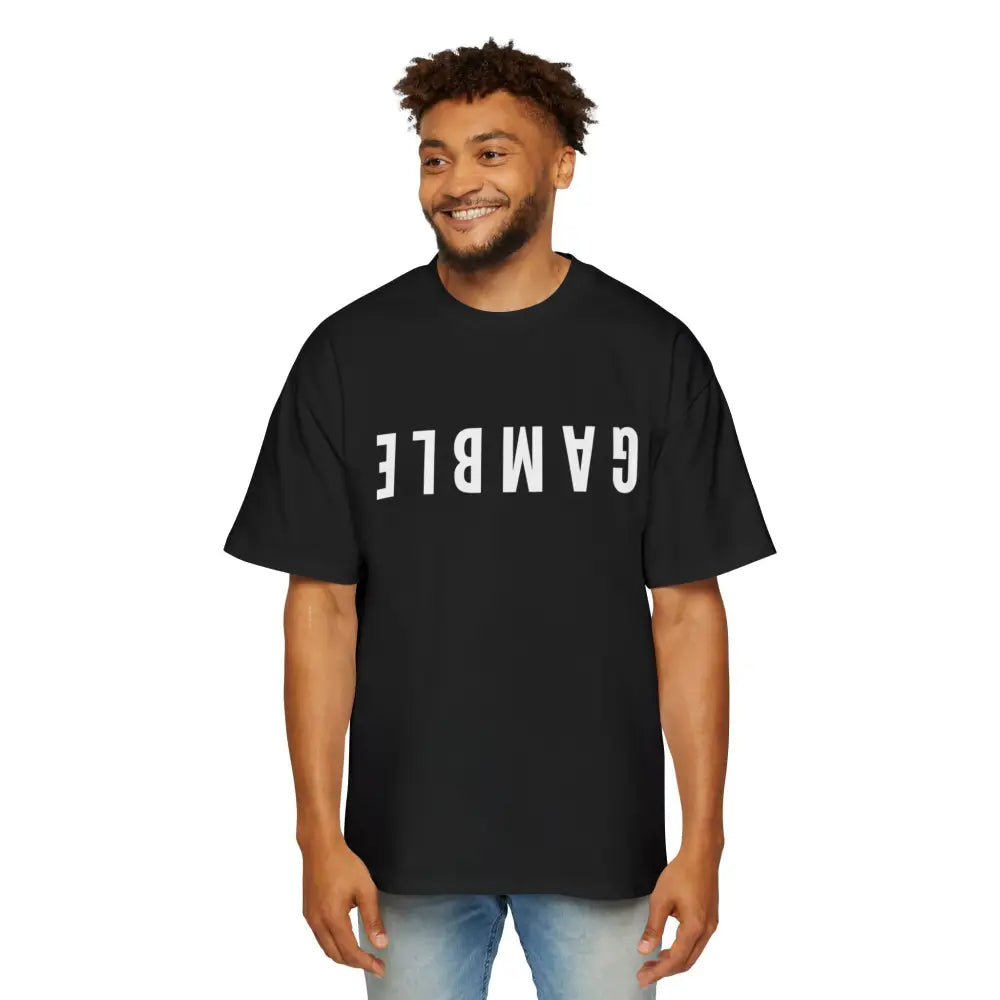 A man wearing a black oversized t-shirt with the word 'GAMBLE' printed in white letters on the front.
