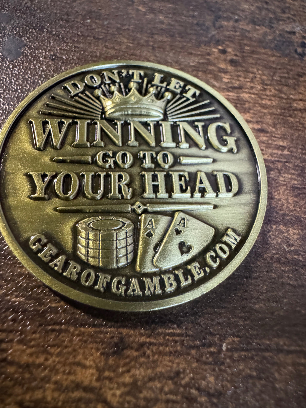 gold card protector coing that says dont let winning go to your head on one side and dont let losing go to your heart on the other side.