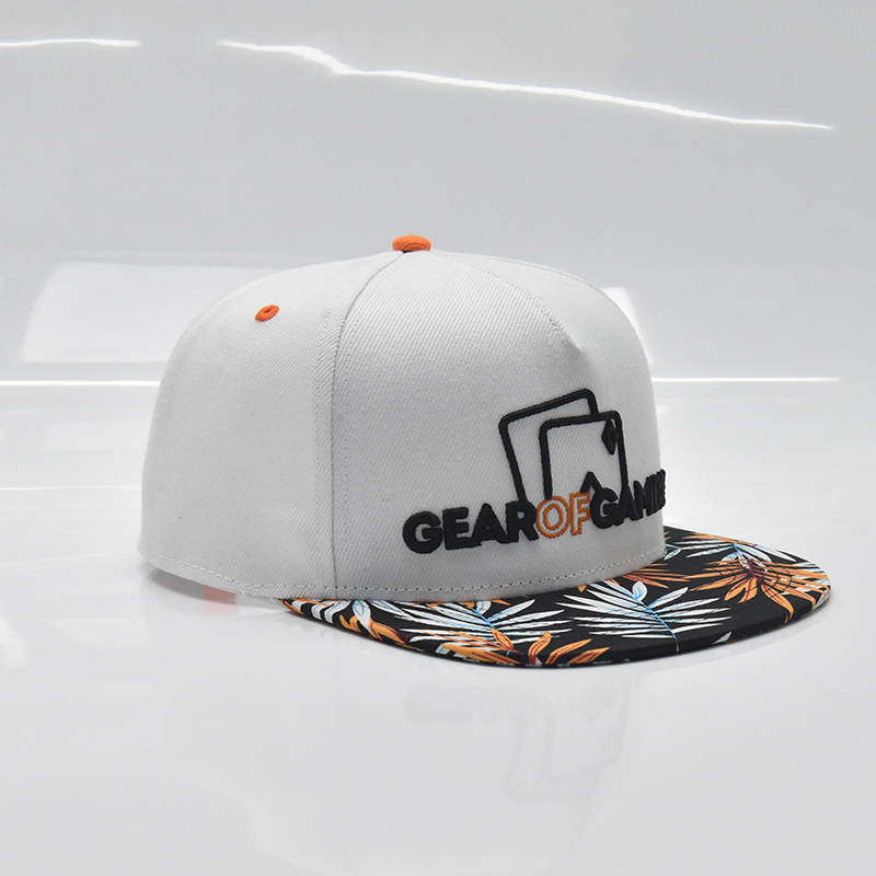 white snapback hat with a bold leaf-patterned brim and Gear of Gamble logo on the side. Perfect poker apparel for players who want to showcase their love for the game with a unique twist
